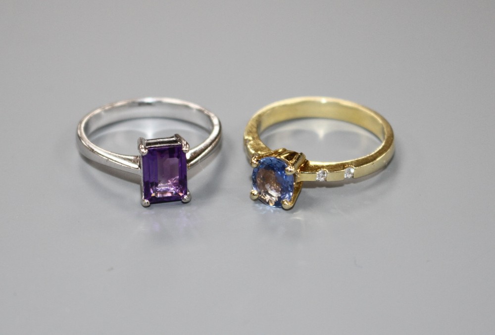A yellow metal and single stone oval cut Ceylon? sapphire ring with diamond set shoulders and a 750 amethyst ring.